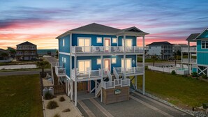 A two-story beachfront house with a balcony, a small pool, and a beach view. - Luxury Ocean View Oasis - Private Pool, Hot Tub, Elevator, 100 Steps to Sand! (Ocean Isle Beach)