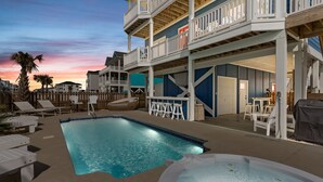 A pool area with lounge chairs, a hot tub, and a bar area with stools. - Luxury Ocean View Oasis - Private Pool, Hot Tub, Elevator, 100 Steps to Sand! (Ocean Isle Beach)