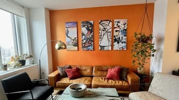 Een woonkamer met een bank, een salontafel en een hangplant.