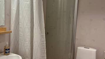 A bathroom with a shower, toilet, and sink.