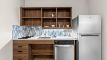 A modern kitchen with wooden cabinets, a built-in dishwasher, and a stainless steel refrigerator.