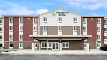 A multi-story hotel with a central entrance, large windows, and a clear sky.