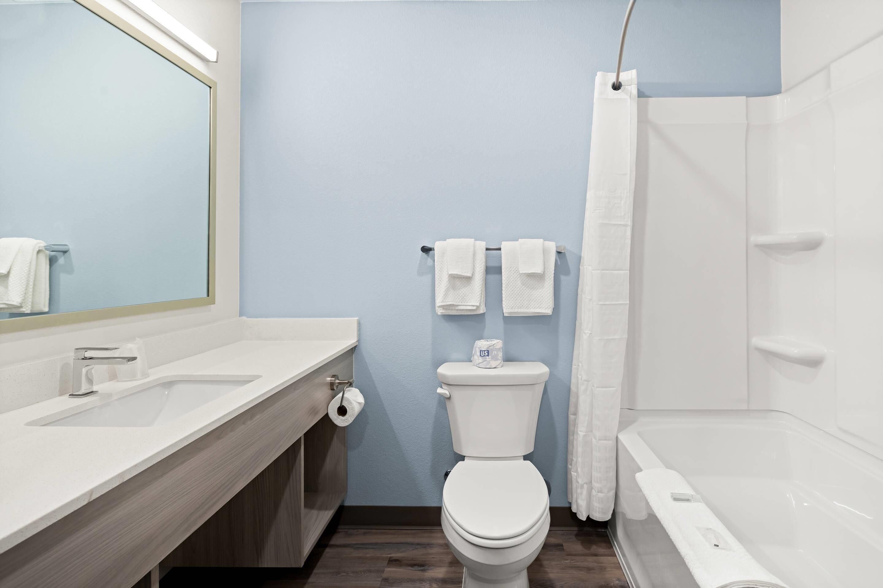 Ein modernes Badezimmer mit einem weißen Waschbecken, einer Toilette und einer Badewanne.