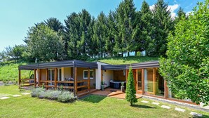 Een modern, twee verdiepingen tellend huis met een overdekt terras, een jacuzzi en een verzorgde tuin.