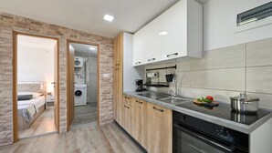 Een moderne keuken met een ingebouwde oven, een koffieapparaat en een spoelbak.