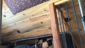 A room with a wooden ceiling, a patterned tapestry hanging, and a staircase with a metal railing. - 2 bedroom adobe home with AC, WiFi, great views, and new sauna and outdoor tub! (Cane Beds)