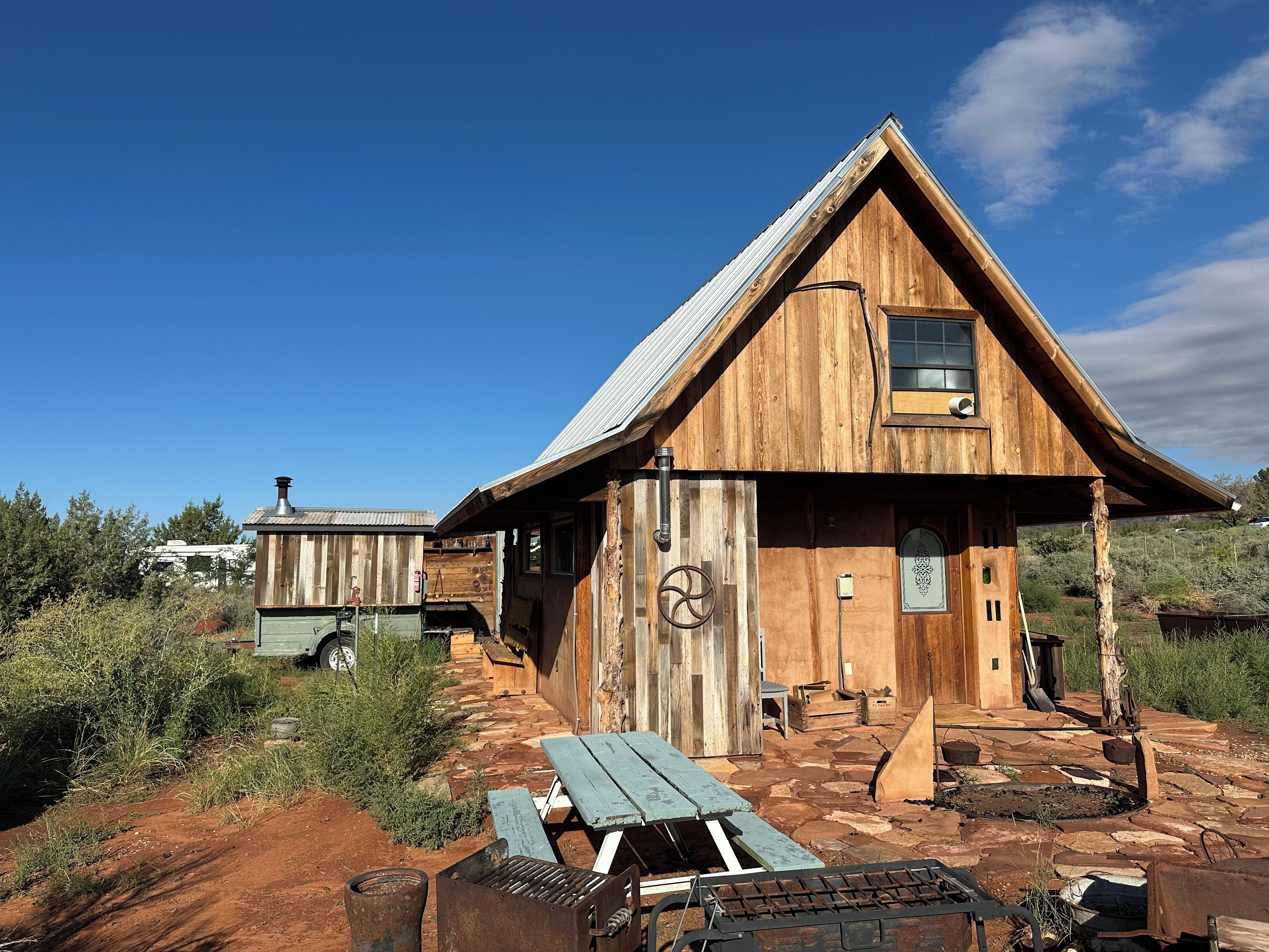 Une cabane rustique en bois, avec un toit en métal, une porte en bois et une fenêtre.