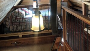 An attic room with wooden beams, a hanging lantern, and a colorful tapestry. - 2 bedroom adobe home with AC, WiFi, great views, and new sauna and outdoor tub! (Cane Beds)