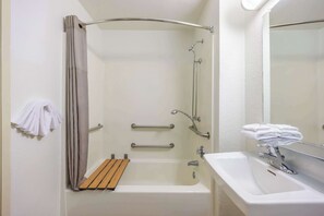 A bathroom with a bathtub, a shower, a sink, and a mirror. - Studio 6 Seattle, WA Sea-tac Airport South (SeaTac)