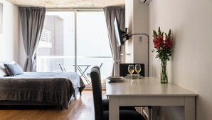 A bedroom with a bed, a small table with two wine glasses, and a vase with flowers. - BT Homes - Palermo Fitz Roy (Buenos Aires)