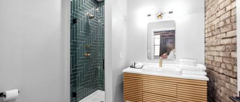 Ein modernes Badezimmer mit Dusche, Waschbecken mit Holzschrank und Spiegel.