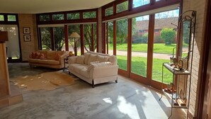 A spacious living room with large windows, two sofas, a rug, and a small table. - Haras Di Cellius (Bage)