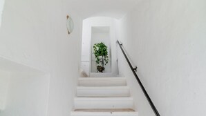 A white staircase with a handrail, leading to a doorway with a plant. - Masseria Carbonico delle Lamie - Ginestra by Rentbeat (Martina Franca)