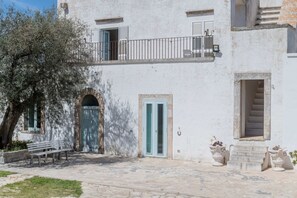 A building with a balcony, a door, and a staircase.
