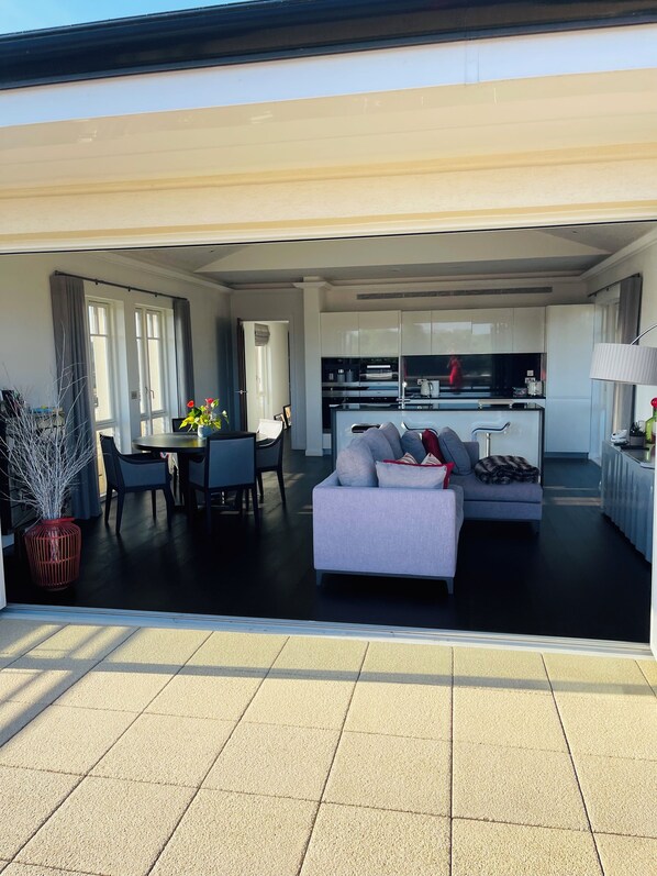 Een modern appartement met een woonkamer, eethoek en keuken.