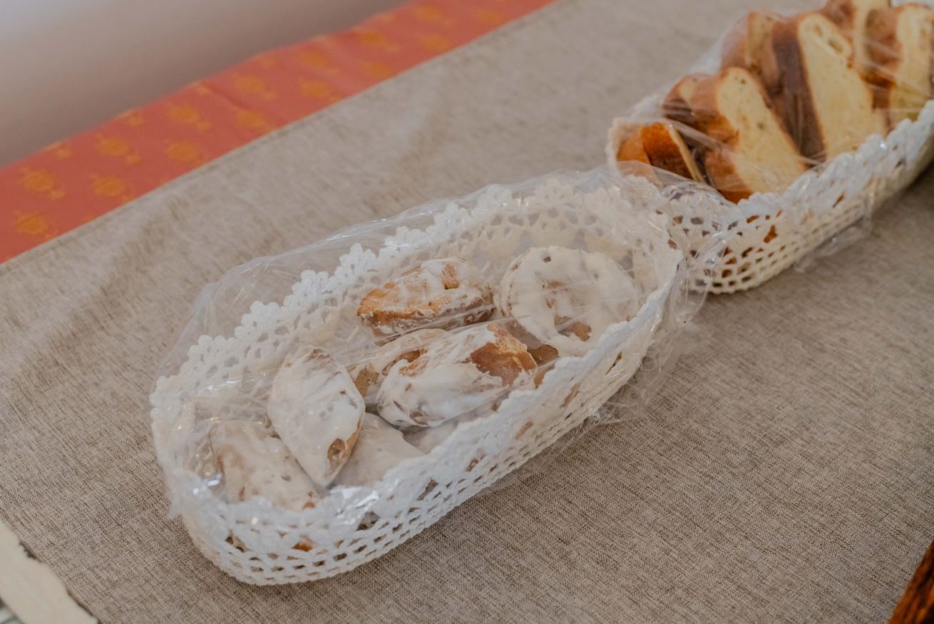 Un panier de pain sur une table, surmonté d'une nappe en dentelle.