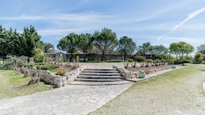 A stone pathway leading to a building, surrounded by greenery and trees. - Masseria Carbonico delle Lamie - Suite by Rentbeat (Martina Franca)