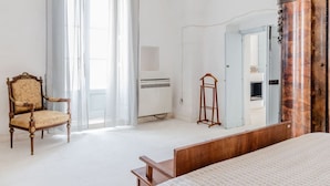 A room with a bed, a chair, a mirror, and a wardrobe. - Masseria Carbonico delle Lamie - Suite by Rentbeat (Martina Franca)