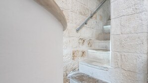 A stone staircase with a metal handrail, leading to a landing. - Portici Guest House by Rentbeat (Fasano)
