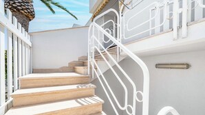 A staircase with white metal railings and beige steps. - Residence Anna by Rentbeat (Villanova)