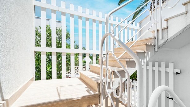A staircase with white railings leading to a wooden deck. - Residence Anna by Rentbeat (Villanova)