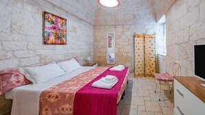 A room with a bed, a desk, a chair, a window with curtains, and a painting on the wall. - Salentina by Rentbeat (Ostuni)
