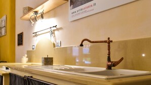 A bathroom with a vintage-style sink, a towel rack, and a wall-mounted towel dispenser.