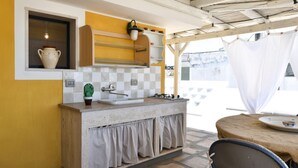 Una cocina con un lavamanos, una estufa y una ventana.