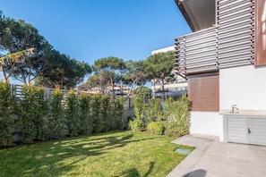 Un edificio moderno con un giardino curato, un garage e un cielo sereno.
