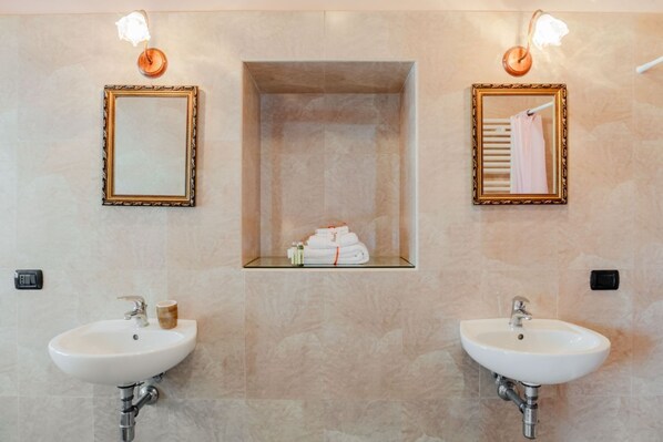 A bathroom with two sinks, a mirror, and a towel rack.
