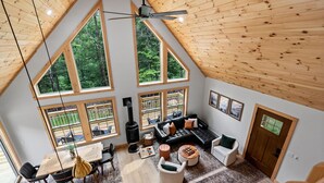 Amplio espacio tipo loft con techos altos, ventanas grandes, chimenea y una zona de estar acogedora.