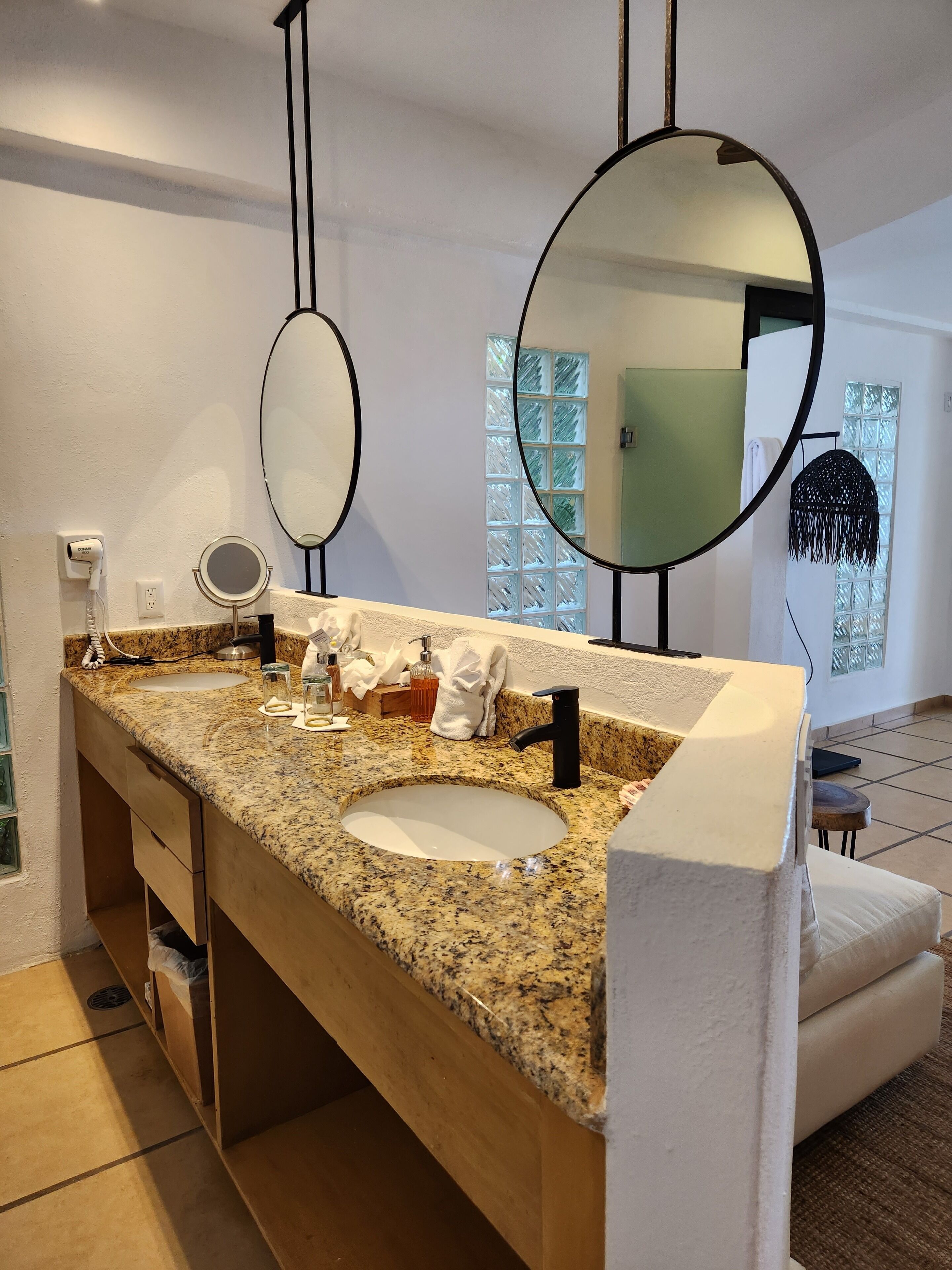 Ein Badezimmer mit Granitplatte, Waschbecken, Spiegel und Handtuchhalter.