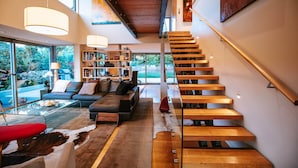 Ein modernes Interieur mit einer Treppe, einem Sofa, einem Couchtisch und einem Bücherregal.