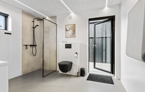 Un baño moderno con cabina de ducha de vidrio, inodoro y bidé.