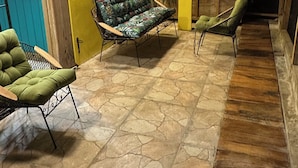 A room with a stone floor, wooden furniture, and yellow walls.