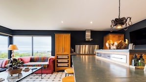 Una cocina moderna con una isla grande, armarios de madera y vistas al exterior.