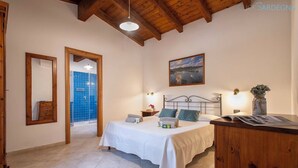 Un dormitorio con cama, mesita de noche y un cuadro en la pared.