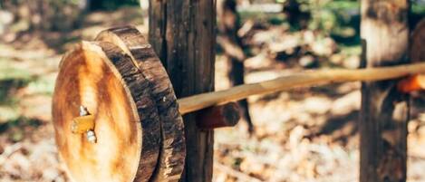 Una rueda de madera unida a un poste en una zona boscosa.