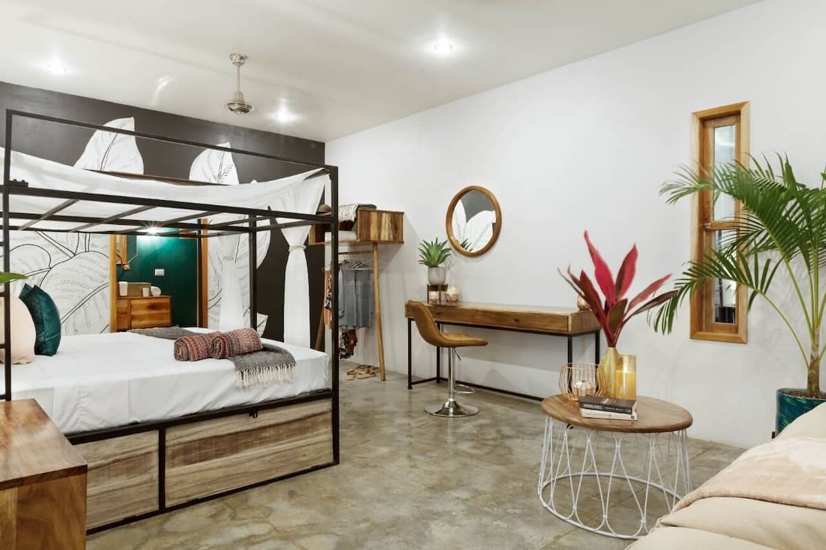 A modern bedroom with a bunk bed, a desk, and a round coffee table.