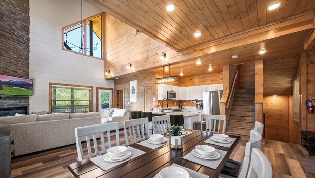 L’intérieur d’une maison en rondins moderne, comprenant un coin repas, une cuisine et un salon.