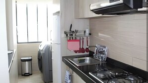 A compact kitchen with a gas stove, a stainless steel sink, and a small trash bin. - BEAUTIFUL APARTMENT IN THE BEST SECTOR OF QUITO (Quito)