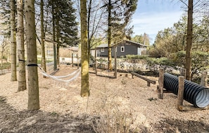 A residential area with a house, a hammock, and a playground.
