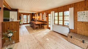 A wooden interior with a dining area, kitchen, and large windows. - 4 bedroom beautiful home in Thyholm (Thyholm)
