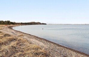 Escape to a serene lakeside haven with a tranquil view of the water and a natural shoreline.