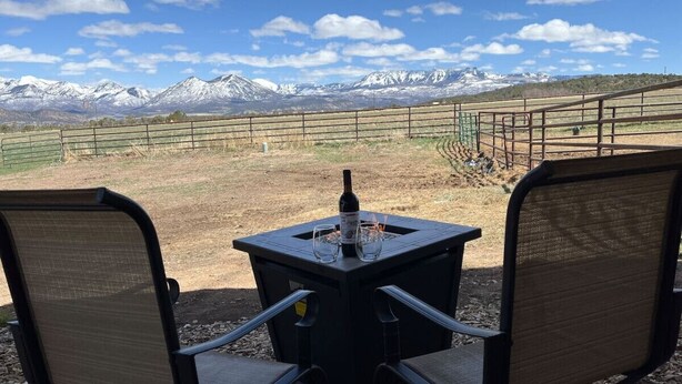 A table with two chairs facing a mountainous landscape.