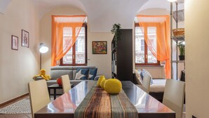 Un espace repas avec une longue table, des chaises et un canapé en arrière-plan.