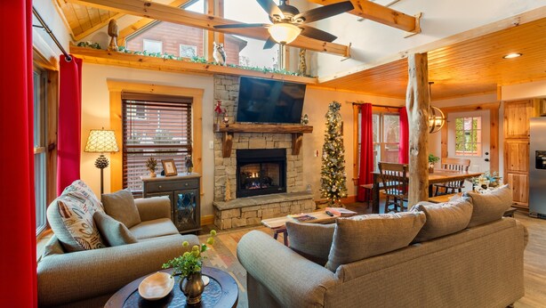 Una sala de estar acogedora con chimenea, asientos cómodos y un comedor.