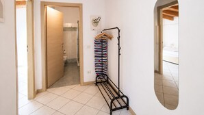 Un couloir avec un banc, un porte-manteau et une porte donnant accès à une salle de bain.