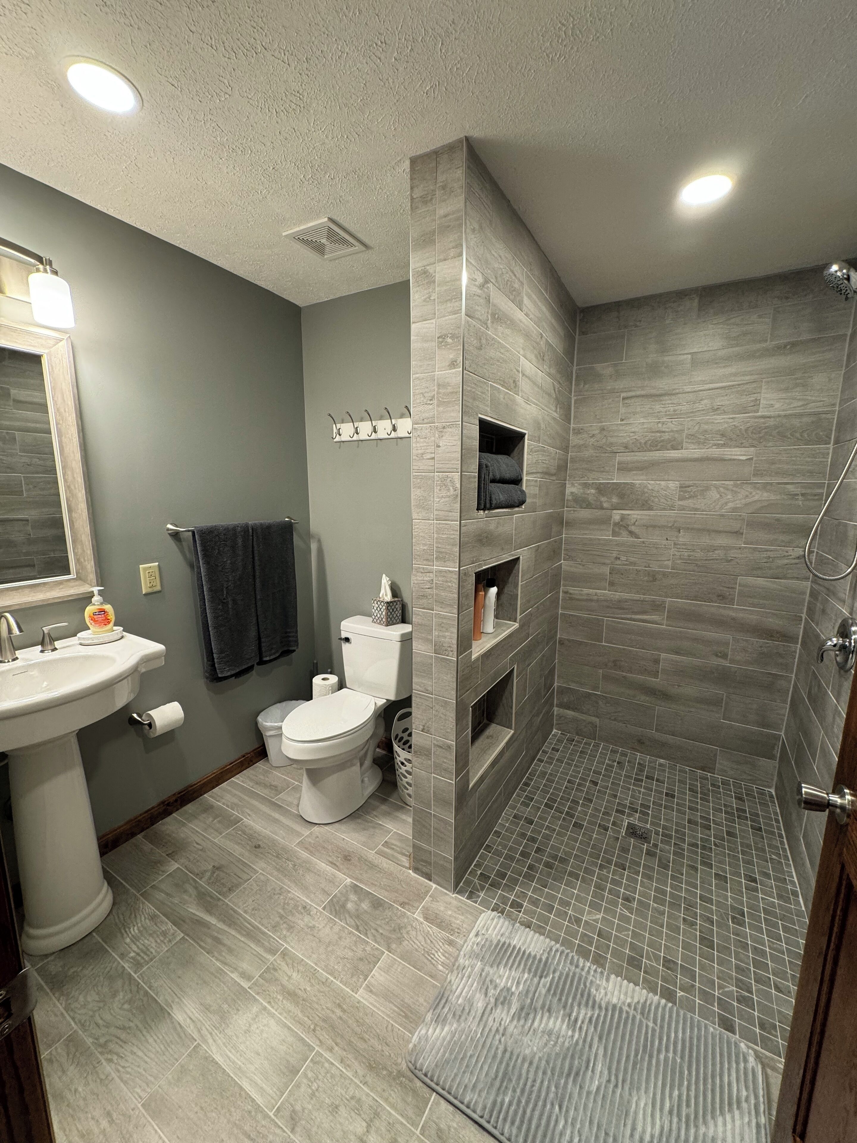 Une salle de bain moderne équipée d’une douche, de toilettes, d’un lavabo et d’un porte-serviettes.