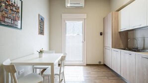 A modern kitchen with white cabinets, a built-in oven, and a window with frosted glass.